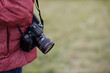 Digital professional film camera Canon on photographer shoulder belt strap.