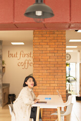 Poster - Vertical shot of the beautiful, young, short-haired woman working on the laptop.