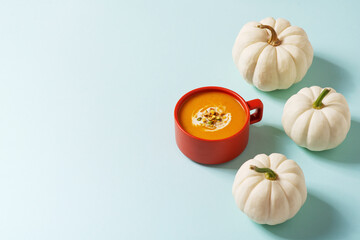 Wall Mural - Autumn pumpkins soup with vegetables on blue background