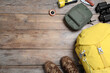 Flat lay composition with tourist backpack and other camping equipment on wooden background, space for text