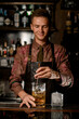 © fesenko - hand of man bartender holds long bar spoon and mixes cold drink into mixing cup