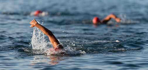 Wall Mural - Triathlon swimmers in the open sea, view from the front