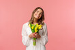 Holidays, beauty and spring concept. Portrait of dreamy, happy blond girl feeling romantic daydreaming about her girlfriend, holding yellow tulips, wear white dress, standing pink background