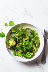 Canvas Print - Green salad with grilled broccoli and olives in white bowl. Vegan food, detox, healthy food concept