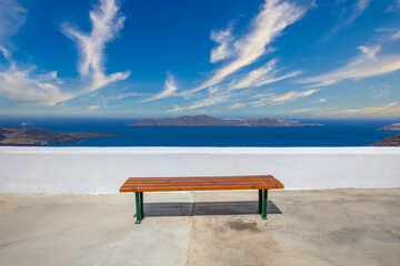 Wall Mural - Santorini, Greece. Picturesque view of traditional cycladic Santorini's details, bench with sea bay view. Relaxing travel landscape
