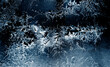 Frozen winter window. Window frozen glass, ice crystals. Beautiful Hoarfrost pattern, rime on black background. Snow, Christmas or New Year backdrop for screen mode use. 
