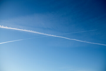 several white condensation airplane trace in deep blue sky
