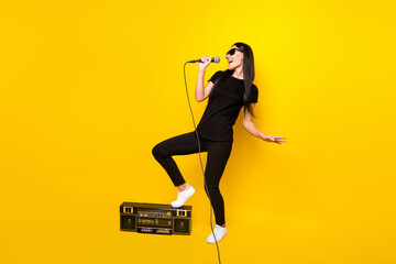 Sticker - Full body portrait of carefree positive person hold mic put leg on boombox isolated on yellow color background