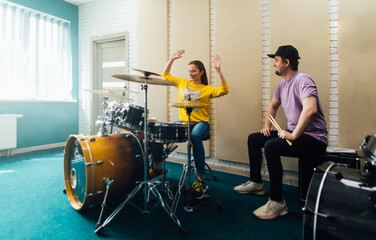 Wall Mural - The teacher explains to a young woman how to play the drum bass.