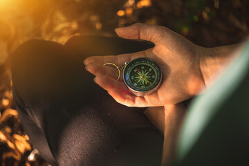 Compass in the forest, hand with the old compass for navigation in the woods