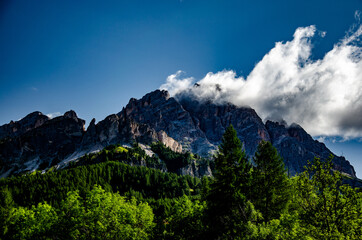 Wall Mural - Scenic shot of the Cortina d'Ampezzo town fields and rocky ski mountain under a cloudy sky in Italy