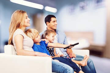 Canvas Print - The happy young family enjoys their free time relaxing together at home.