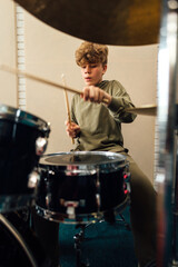 Wall Mural - Boy enjoys playing the drums.