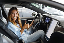 Side View Happy Fun Smiling Confident Satisfied Woman Drive Hold Put Hand On Steering Wheel Look At Maps On Tablet Show Thumb Up Sitting In Auto New Car Automobile Journey Traveling Lifestyle Concept.