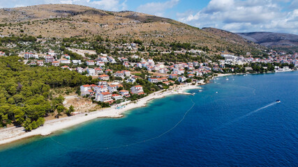 View of the sea coast in the town of Trogir. Beach and yachts in the Adriatic Sea. Mountains in the background. Dalmatia. Croatia. Europe