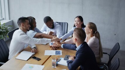 Wall Mural - Group of successful coworkers discussing new project plan, stacking hands together and laughing during meeting
