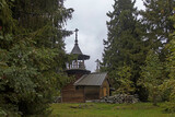 Fototapeta  - The chapel of Paraskeva Pyatnitsa and Varlaam Khutynsky is located at some distance from the coastline of Lake Onega on an elevated place, among a group of fir trees.