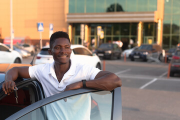 Wall Mural - An African-American man holds a car key in his hands. Buying and renting a car