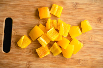 Wall Mural - Yellow Bell Pepper Sliced into Large Chunks: Sweet yellow pepper cut into large pieces on a bamboo cutting board
