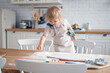 © muse studio - A beautiful baby is having fun alone. A small blonde child is playing at home. A girl cooks cookies in the kitchen.