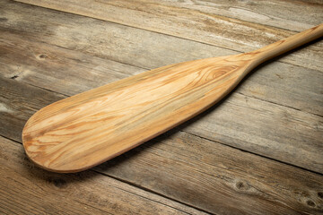 Wall Mural - blade of wooden canoe paddle against rustic weathered wood