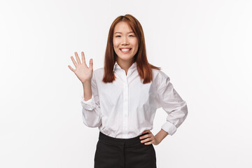 Portrait of friendly pleasant and happy young asian woman waving to you as saying hi, greeting newcomers, welcome to team, introduce herself make hello gesture, white background