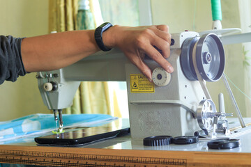 close up of a hand setting and repairing an electric sewing machine using a screwdriver