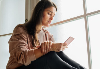 Wall Mural - Serious and distressed woman using a smartphone