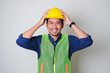 © KrishnaTedjo - Asian construction worker smiling confident while holding his yellow hard hat