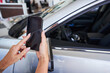 © Svitlana - Woman using modern gadget in car dealership