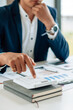 © PaeGAG - Businessman's hands with calculator at the office and Financial data analyzing counting on wood desk