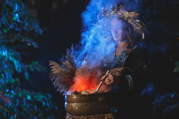 A forest witch brews a potion holding a Voodoo doll.