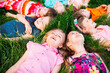 © davit85 - A group of children lying on the green grass in the Park. The interaction of the children.
