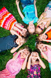 © davit85 - A group of children lying on the green grass in the Park. The interaction of the children.