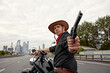 © Georgii - mafia man on bike with handgun. Sporty biker handsome rider male. Chase