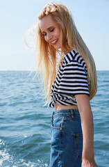 Poster - Beautiful young woman near sea on sunny day in summer