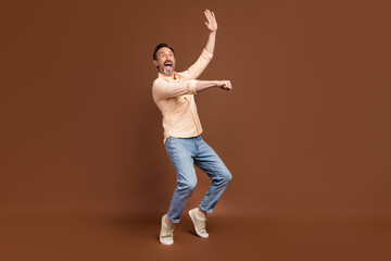 Poster - Photo of crazy funky guy dance imagine ride horse wear beige shirt jeans shoes isolated brown color background