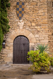 Fototapeta Na drzwi - pintoresca puerta de madera en muro castillo de montsonis con escudo medieval