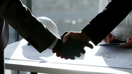 Close up two business partners shake hands meeting in office