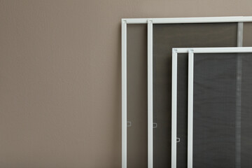 Wall Mural - Set of window screens near beige wall. Space for text