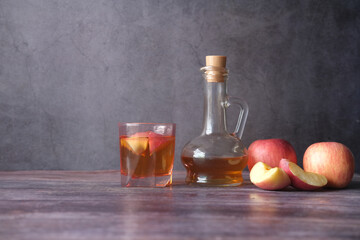 Wall Mural - apple vinegar in glass bottle with fresh green apple on table 