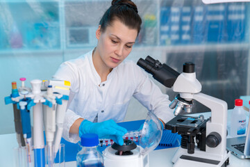 Wall Mural - Young woman in clinical lab does PCR test on  viral disease