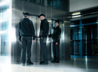 Wall Mural - Security guards standing in corridor near elevator