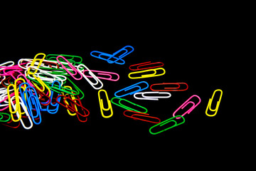 Sticker - Closeup shot of colored paper clips isolated on a dark background