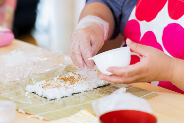 Wall Mural - 料理教室で巻き寿司を作る女性の手元