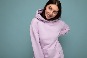 Photo of beautiful positive smiling adult woman wearing stylish clothes standing isolated on colorful background with copy space looking at camera