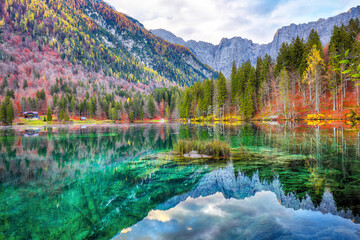 Breathtaking view of sunset over Fusine lake with Mangart peak on background.