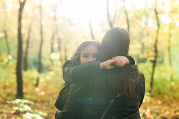 Wall Mural - Mother and daughter spend time together in autumn yellow park. Season and single parent concept.