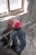 © astrosystem - Real construction worker working on a wall inside the new house.
