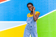 Energetic Black Woman Standing Against Colorful Wall